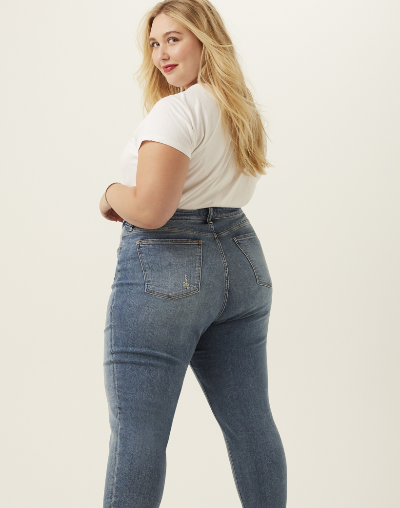 plus size woman in white tee and medium wash denim jeans